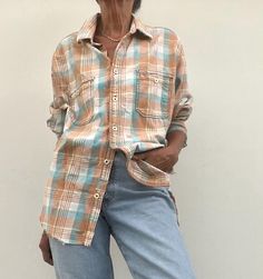 an older woman wearing jeans and a plaid shirt