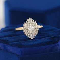 a diamond ring sitting on top of a blue velvet box