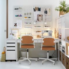 two office chairs sitting next to each other in front of a desk with pictures on the wall