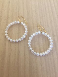 "Hoop earrings are always fun, and certainly kicked up a notch when the hoops are covered in pearls! 14K gold plated sterling silver wire is used to form the hoops. Luscious 4-4.5mm white cultured freshwater pearls circle up for a fun and flirty or dressy and classic earring. Approximate diameter is 1.25\". Gold plated sterling silver French ear wire settings allow the hoops to dangle freely. Handmade in Charleston SC, single person small business" Everyday Pearl Hoop Earrings, White Pearl Charm Hoop Earrings, White Small Hoop Pearl Earrings With Ear Wire, White Pearl Small Hoop Earrings With Ear Wire, 14k Gold Filled Pearl Charm Hoop Earrings, White Pearl Hoop Earrings With Pearl Charm, 14k Gold-filled Round Pearl Earrings With Charm, Small Hoop Pearl Earrings, White Small Hoop Pearl Chain Jewelry