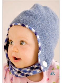 a baby wearing a blue hat with a checkered scarf around it's neck