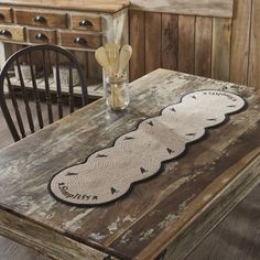 a wooden table topped with a white doily on top of a wooden table next to a chair