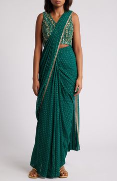 This saree has a hand-embroidered cropped top with intricate beadwork and lustrous sequins and is paired with a skirt featuring attached wraparound draping. This outfit is prestitched, so you can put it together in 30 seconds or less. V-neck Top has hook-and-eye closure; skirt has hidden side-zip closure Top and skirt feature hook-and-eye attachments for easy drape adjustments Lined 100% viscose Spot clean Made in India Asian & Pacific Islander Owned/Founded Traditional Draped Choli With Zari Work, Traditional Draped Choli With Mirror Work, Traditional Embellished Pre-draped Saree For Festive Season, Traditional Draped Lehenga With Mirror Work, Party Wear Draped Saree With Zari Work, Festive Georgette Pre-draped Saree, Party Wear Pre-draped Saree With Zari Work, Festive Saree With Zari Work And Side Open Design, Party Wear Pre-draped Saree With Sequins