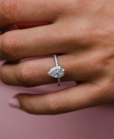 a woman's hand with a diamond ring on it