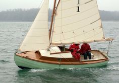 two people on a small sailboat in the water