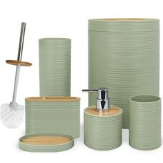 the bathroom accessories are all green and have wooden handles on each one side, along with a toilet brush