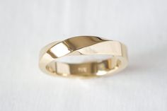 a gold wedding ring on a white background