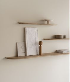 two shelves with books and other items on them, one shelf is made from plywood