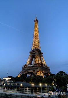 the eiffel tower lit up at night with lights on it's sides