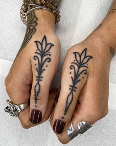 two hands with tattoos on them and one has a flower tattoo on the other hand