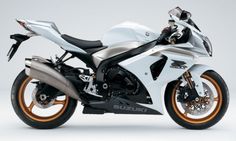 a white and black motorcycle is shown on a gray background with an orange stripe around the tire rims