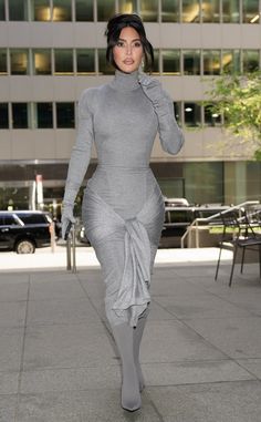 a woman in grey dress walking down the street