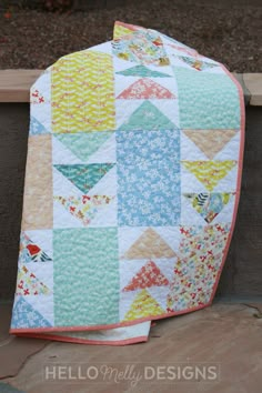 a quilted blanket sitting on top of a wooden bench