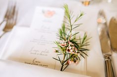 a place setting with napkins, silverware and flowers