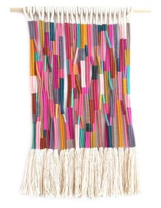 a colorful wall hanging with fringes on it