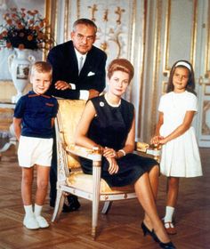 an older man and two young children are posing for a photo in front of a chair