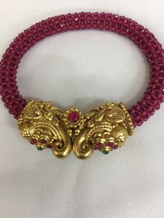 A new addition to our product line by our artisans. A beautiful piece for our traditional Indian Bride! Notice the gorgeous carving work on the twin elephant figure at the center and the red-colored beaded mesh at the base. Material: Brass and copper mix, gold plated, beads The bracelet is the same as shown in the picture and in the video. We have only one piece in this design and color and hence you get what you see in the picture. For wrist sizes 2.4- 2.6 Easily openable with a screw. Red Ruby Temple Necklace With Intricate Design, Red Intricate Design Temple Necklace For Festive Occasions, Traditional Red Temple Necklace With Zari Work, Red Motif Jewelry For Rituals, Red Motifs Jewelry For Rituals, Red Beaded Temple Necklace For Festivals, Red Jewelry With Motifs For Rituals, Festive Red Beaded Temple Necklace, Festive Red Temple Necklace With Zari Work