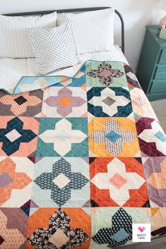 a bed with a colorful quilt on top of it