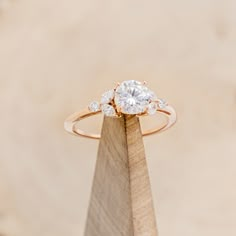 a diamond ring on top of a wooden stand