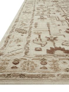 a beige and brown rug with an intricate design