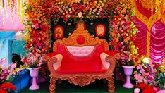 an elaborately decorated stage set up for a wedding ceremony with flowers and decorations on the walls