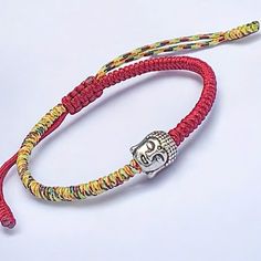 a red rope bracelet with a silver skull charm