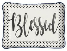 a black and white polka dot pillow with the word,'blessed'in cursive