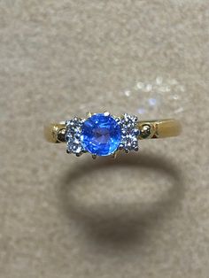 Unheated Burmese Sapphire with Natural Diamond 18K Solid Yellow Gold. Weight of sapphire 0.88ct. Weight of natural diamond 4pcs-0.10ct. Length and width of sapphire  5.2x5.2mm. Length and width of sapphire and diamond 9x5.2mm. Total weight of ring 2.1gm. Gemstone -  Unheated Burmese sapphire   Transparency -  Transparent  Could  -  Sky Blue  Clarity - VVS  Treatments  -  None  Hardness   -   9 Origin of sapphire Mogok Myanmar (Burma) Sparkle and look blue diamond. Micro chip on the surface. Ring size 6 Condition -Brand New Certificate of Guarantee Final fixed price  Made in Myanmar (Burma) Ready to ship in next day. Please feel free to message me for any questions related to the piece. Brilliant Cut Sapphire Diamond Gemstones, Blue Sapphire Gemstone With Center Stone, Blue Sapphire Ring With Single Cut Diamonds, Round Sapphire Gemstones For Anniversary, Sapphire Gemstones For Anniversary, Classic Gemstones With Diamond Accents, Classic Diamond Gemstones With Diamond Accents, Blue Diamond Gemstones In Round Cut, Dazzling Sapphire Gemstones For Anniversary