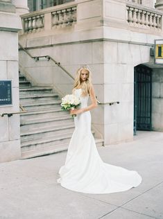 a beautiful blonde woman in a white dress holding a bouquet