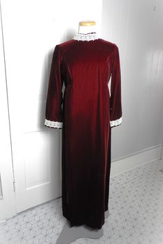 Old New Stock 1970's Red Velvet Formal Dress|Vtg Retro Full Length Red Preppy Dress|Mod Red Velvet Lace Trim Long Dress Made in USA sz S This is an amazing vintage 1970's long formal maxi dress in red faux velvet.  This looks to have not been worn although there are no original tags present here.  The collar is a mock turtleneck in white lace with the same lace at the cuffs of the long sleeves.  The sleeve is a 3/4" sleeve. There is a full back zipper with a large bow at the waistline that secur Red Vintage Costume Dress, Vintage Red Dress With Lace Trim, Red Vintage Dress With Lace Trim, Red Long Sleeve Vintage Dress, Retro Red Wedding Dress, Red Vintage Dress For Fall, Vintage Long Dresses For Formal Occasions, Vintage Burgundy Dress For Evening, Vintage Burgundy Evening Dress