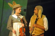 two people dressed in costumes and holding musical instruments