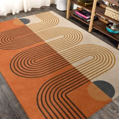 an orange and brown area rug with circles on the floor in front of a book shelf