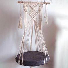 a hammock hanging from the ceiling with tassels on it's sides