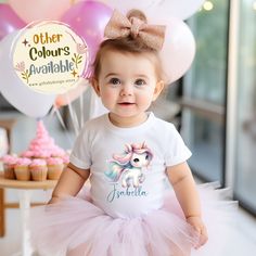 Introducing our Personalised Birthday T-shirt: Personalised Birthday Unicorn Name T-shirt edition, the perfect way for your little one to celebrate a magical birthday with sweetness and charm. Featuring a beautiful unicorn with rainbow tail and mane, this T-shirt offers a whimsical and enchanting design that captures the imagination and excitement of childhood celebrations. It's a fabulous choice for any child who loves unicorns and dreams of a birthday filled with magic. Available in sizes rang Cute White T-shirt With Unicorn Print, Rainbow Short Sleeve Top For Birthday, Rainbow Short Sleeve Top For Birthdays, Cute Unicorn Print Birthday T-shirt, Birthday Unicorn Print Crew Neck T-shirt, White Unicorn Print T-shirt For Birthday, Birthday White T-shirt With Unicorn Print, White T-shirt With Unicorn Print For Birthday, White Unicorn Print Top For Birthday