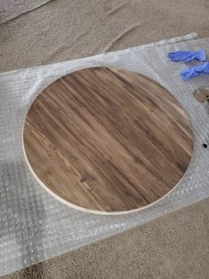 a round wooden table sitting on top of plastic