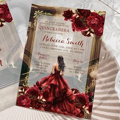 two red roses are in front of a wedding card with an image of a woman wearing a red dress