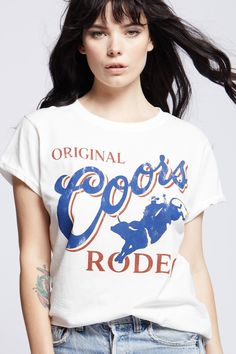 Kick back and take a wild ride with this vintage Original Coors Rodeo tee. In 1987, Coors kicked off the summer with their iconic rodeo events as a tribute to western heritage. This soft cotton fitted tee is perfect for the rodeo, with vintage distressed hems, rolled short sleeves, and a ribbed crewneck. The design of this style is fitted. For a more standard fit choose a size up. Details Style #302145 Color: White Wild Vintage Original Coors Rodeo Fitted T-Shirt 100% Cotton Care/Import Machine Vintage Summer T-shirt For Rodeo, Retro T-shirt For Summer Country Concerts, Crew Neck T-shirt For Western-themed Spring Events, White Graphic Tee For Rodeo, Fitted Graphic Print T-shirt For Rodeo, Graphic Tee For Western-themed Spring Events, Spring Graphic Tee For Western-themed Events, Retro Crew Neck Tops For Western-themed Events, Vintage Cotton Tops For Rodeo