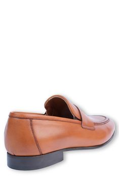 Handmade of smooth leather, this moc-toe dress shoe with a classic penny loafer silhouette offers a sophisticated, elegant look. Leather upper and lining/synthetic sole Made in Turkey Cognac Round Toe Loafers For Semi-formal Occasions, Semi-formal Cognac Loafers With Round Toe, Classic Cognac Slip-on Moccasins, Classic Cognac Leather Slip-on Shoes, Cognac Leather Moccasins For Business, Cognac Leather Moc Toe Loafers, Cognac Loafers With Leather Sole, Cognac Loafers With Moc Toe And Leather Sole, Cognac Loafers With Leather Sole And Plain Toe