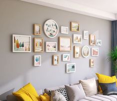 a living room filled with lots of furniture and framed pictures on the wall above it