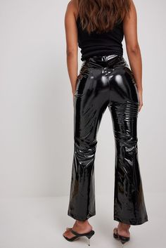 These pants feature a flared leg, a side zipper closure and a high waist fit. Bell Bottoms Leather Pants, Latex Flare Pants, Vinyl Straight Leg Pants, Black Pvc Pants, Luxury Chic Flared Leather Pants, Luxury Fitted Shiny Pants, Latex Bell Bottom Pants, Vinyl Black Pants, Latex Wide Leg Pants