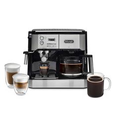 an espresso machine with two cups of coffee next to it on a white background