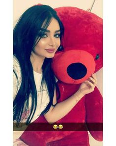 a woman holding a large red teddy bear