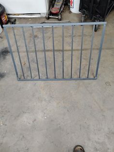 a pair of shoes sitting next to a metal gate in a garage with tools on the floor