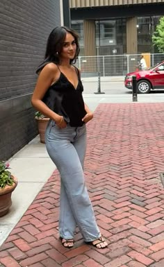 a woman standing on a brick sidewalk next to a fire hydrant