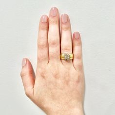 a woman's hand with a yellow gold ring on top of her left hand