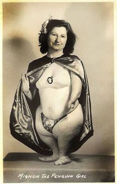 an old photo of a woman wearing a cape and posing for the camera with her hands on her hips