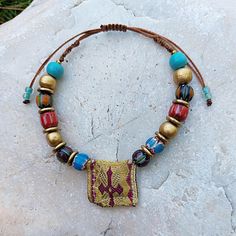 Discover the beauty and spiritual significance of this unique handmade Greek talisman amulet bracelet. Adorned with vibrant, multi-colored nepalese beads, wooden beads , bronze details and a distinctive fabric Greek amulet centerpiece, this bracelet combines traditional craftsmanship with a modern boho style. The adjustable cord ensures a comfortable fit for any wrist size. Perfect as a meaningful gift or a special addition to your own jewelry collection, this piece carries the essence of ethnic Bohemian Beaded Bracelets For Festivals And Gifts, Handmade Spiritual Friendship Bracelets For Festivals, Multicolor Bracelets For Festivals, Traditional Hand Wrapped Beaded Bracelets, Spiritual Hand Wrapped Beaded Bracelets For Festival, Bohemian Friendship Bracelets With Large Beads, Traditional Friendship Bracelets With Colorful Beads, Spiritual Festival Bracelet Beads, Handmade Multicolor Bracelets For Rituals