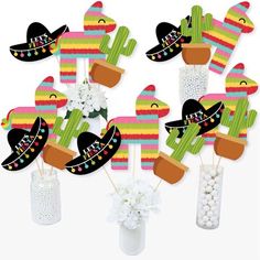 mexican themed cupcake toppers in a vase filled with flowers and cactus decorations for a cinco de mayo birthday party