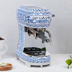 a blue and white coffee machine sitting on top of a counter