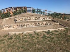 the steps are made out of rocks and stones in front of a wooden fence on top of a hill